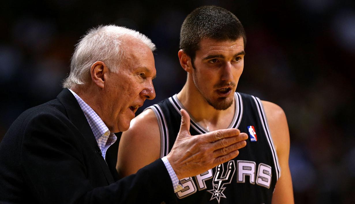 Pebasket San Antonio Spurs, Nando de Colo berbincang dengan pelatihnya, Greg Popovich saat laga melawan Miami Heat di American Airlines Arena, Miami, Florida, 29 November 2012. De Colo merupakan salah satu pemain terbaik Prancis yang berlaga di EuroLeague. Sayangnya, kariernya malah meredup di NBA. Ia pernah membela Spurs pada 2012 hingga 2014 dengan mencatatkan 98 laga. (AFP/Getty Images/Mike Ehrmann)