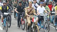 Presiden Joko Widodo atau Jokowi (tengah) didampingi Gubernur Jawa Barat Ridwan Kamil (kanan) saat mengikuti Bandung Lautan Sepeda, Sabtu (10/11). Kegiatan ini dalam rangka memperingati Hari Pahlawan. (Liputan6.com/Angga Yuniar)