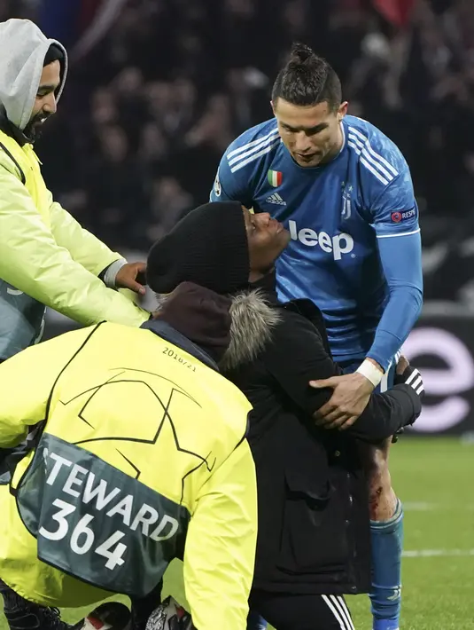 Seorang penggemar berlutut di depan penyerang Cristiano Ronaldo selama pertandingan antara Lyon dan Juventus pada leg pertama babak 16 Liga Champions di Stadion Olimpiade Lyon di Decines, Prancis (26/2/2020). Dalam pertandingan ini Lyon berhasil mengalahkan Juventus 1-0. (AP Photo/Laurent Cipriani)