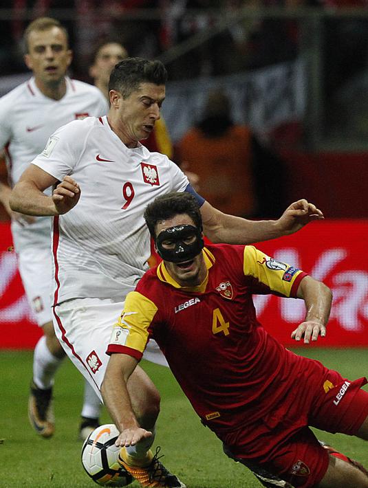 Striker Polandia, Robert Lewandowski, berebut bola dengan gelandang Montenegro, Nikola Vukcevic, pada laga Kualifikasi Piala Dunia 2018 di Stadion National, Warsawa Minggu (8/10/2017). Polandia menang 4-2 atas  Montenegro. (AP/Czarek Sokolowski)