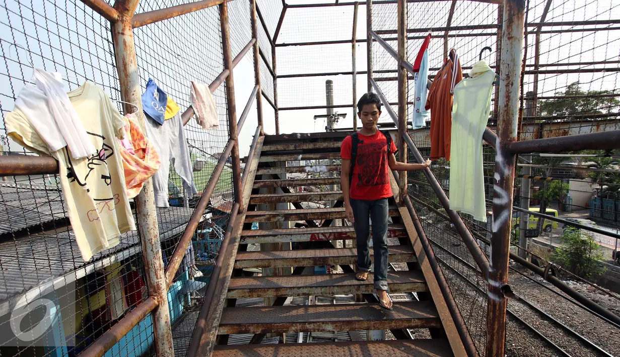Warga menuruni anak tangga di Jembatan Penyeberangan Orang yang rusak di kawasan Tebet, Jakarta, Kamis (5/11). Kondisi jembatan yang sudah berkarat dan berlubang tersebut membahayakan pejalan kaki terutama saat malam hari. (Liputan6.com/Immanuel Antonius)