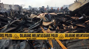 Garis polisi terpasang di lokasi kebakaran yang melanda wilayah permukiman di Jalan Gotong Royong, RW 002 Pondok Bambu, Jakarta, Senin (8/8). Polisi masih mengusut penyebab kebakaran yang menghanguskan 90 rumah tersebut. (Liputan6.com/Johan Tallo)