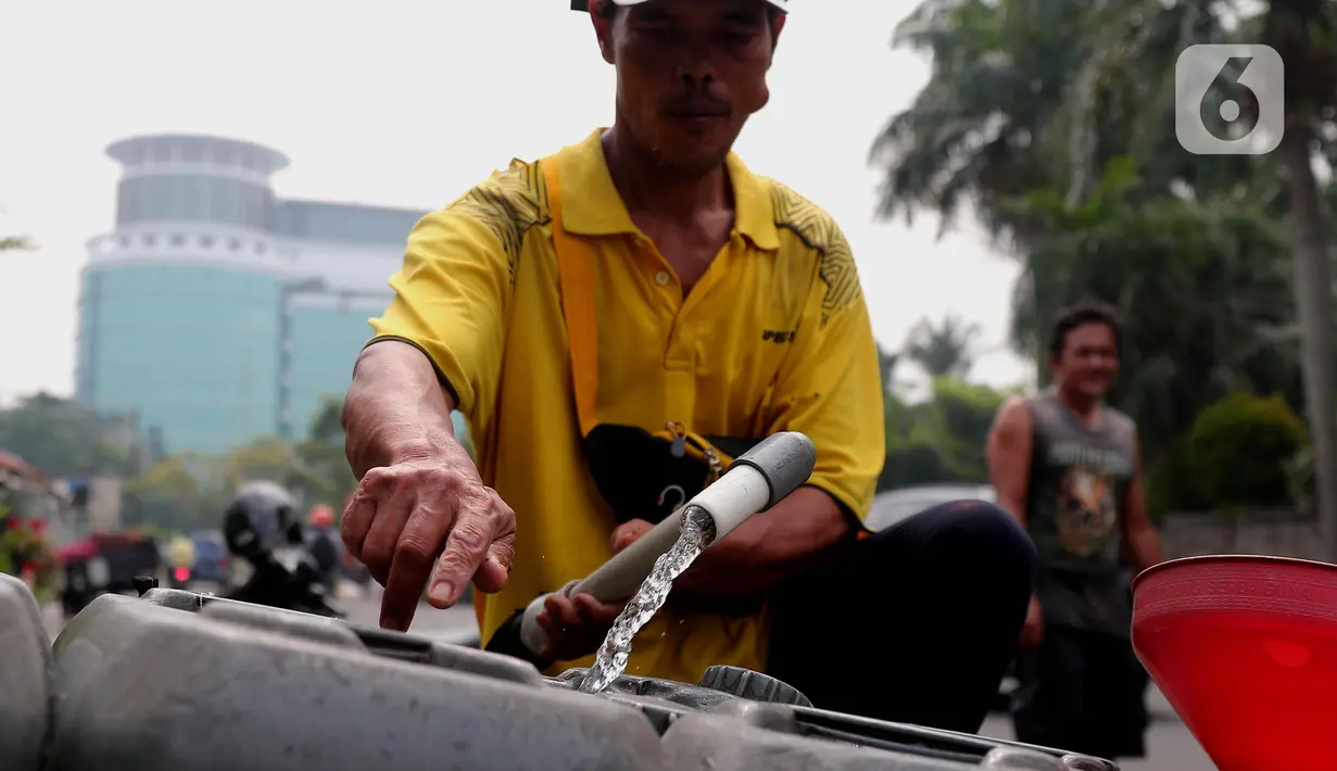 Pedagang tengah mengisi air  bersih ke dalam drigen untuk dijual di Kembangan, Jakarta, Rabu (13/7/2022). Air bersih yang dijual seharga 5 ribu per drigen tersebut untuk memenuhi kebutuhan air bersih bagi warga sekitar kawasan tersebut. (Liputan6.com/Angga Yuniar)