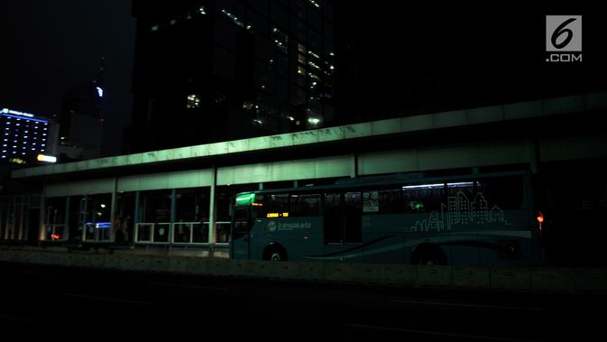 Bus Transjakarta berhenti untuk mengangkut penumpang saat listrik padam di Halte Tosari, Jakarta, Minggu (4/8/2019). Pemadaman listrik serentak yang terjadi sejak Minggu siang mengubah suasana malam di ibu kota menjadi gelap gulita. (merdeka.com/Iqbal S. Nugroho)