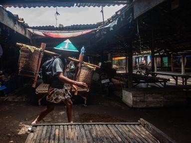 Seorang pria dari masyarakat adat Bonokeling berjalan melewati pasar selama prosesi tradisi Unggah-unggahan di Banyumas, Jawa Tengah, pada 20 Februari 2025. (DEVI RAHMAN/AFP)