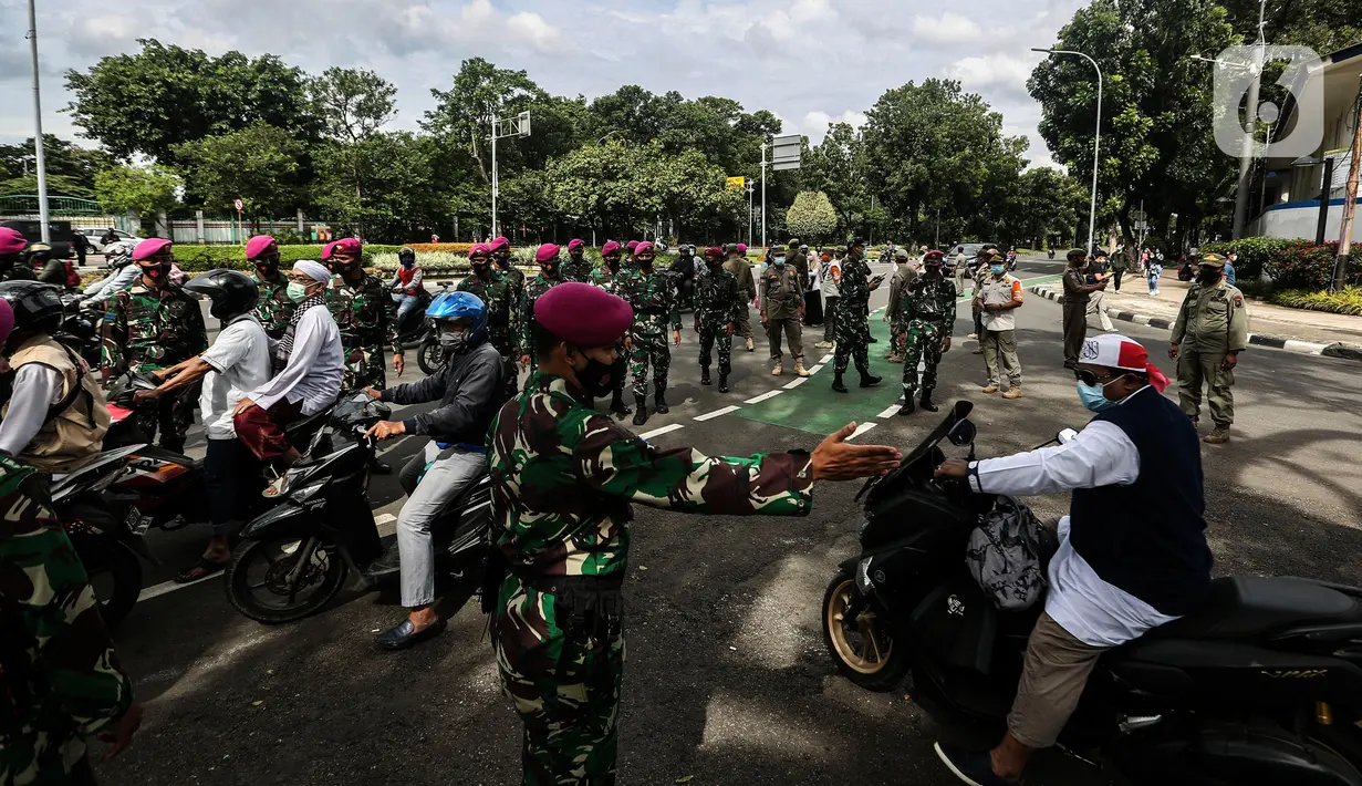 Prajurit TNI menghalau massa yang hendak menggelar demonstrasi 1812 di sekitar Istana Negara, Jakarta, Jumat (18/12/2020). Massa Aksi 1812 dihimbau oleh aparat yang bertugas agar membubarkan diri dan tidak berkerumun demi menghindari penyebaran COVID-19. (Liputan6.com/Johan Tallo)