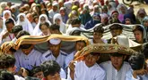 Sejumlah pelajar dan warga melindungi diri dari terik matahari saat mengikuti salat Istisqa untuk memohon turunnya hujan di tengah kekeringan berkepanjangan akibat fenomena El Niño di Malang, Jawa Timur, Kamis (22/10/2026). (Hayu Yudha/AFP)