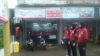 Aksi karyawan yang menghormat ke tiang besi sambil hujan-hujanan itu sempat memancing kemarahan seorang pengunjung minimarket. (Liputan6.com/Eka Hakim)