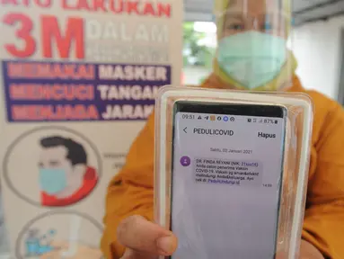 Paramedis menunjukkan SMS undangan mengikuti kegiatan vaksin Covid-19 di Puskesmas  Ciganjur, Jakarta Selatan, Kamis (7/1/2021). Direncanakan pelaksanaan vaksin Covid-19 pada 14 Januari besok dengan prioritas bagi para tenaga kesehatan. (merdeka.com/Arie Basuki)