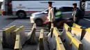 Pejalan kaki menghindari beton pembatas jalan yang diletakkan di atas trotoar Jalan Medan Merdeka Utara, Jakarta, Kamis (25/7/2019). Pembatas jalan yang berada tidak pada tempatnya mengganggu kenyamanan pejalan kaki yang melintasi trotoar jalan tersebut. (Liputan6.com/Helmi Fithriansyah)