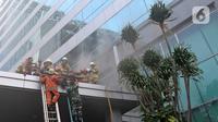 Petugas pemadam kebakaran mengevakuasi korban kebakaran di Gedung Cyber 1, Jakarta, Kamis (2/12/2021). Saat melakukan evakuasi, petugas pemadam kebakaran menemukan tiga orang dalam keadaan tak sadarkan diri di dalam gedung. (Liputan6.com/Herman Zakharia)