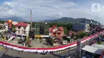Pelajar SMA membentangkan bendera Merah Putih sepanjang 2,3 kilometer di Jalan Panjaitan dan Jalan Nani Wartabone, Gorontalo, Kamis (23/1/2020). Acara tersebut dilakukan untuk mengenang 78 tahun Hari Patriotik. (Liputan6.com/Arfandi Ibrahim)