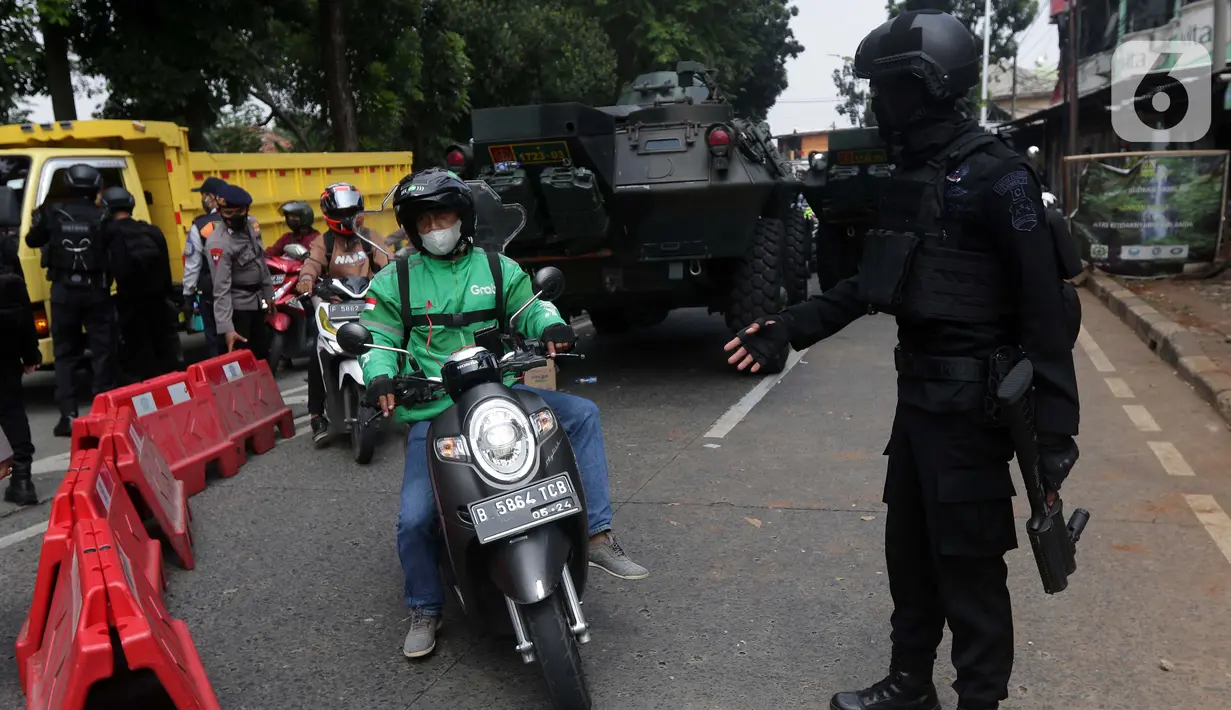 Pengemudi ojek daring melintas lokasi penyekatan di Jalan Lenteng Agung Raya, Jakarta, Selasa (6/7/2021). Petugas hanya mengizinkan warga yang memiliki kepentingan esensial atau mendesak bisa melintas jalan Lenteng Agung Raya. (Liputan6.com/Helmi Fithriansyah)
