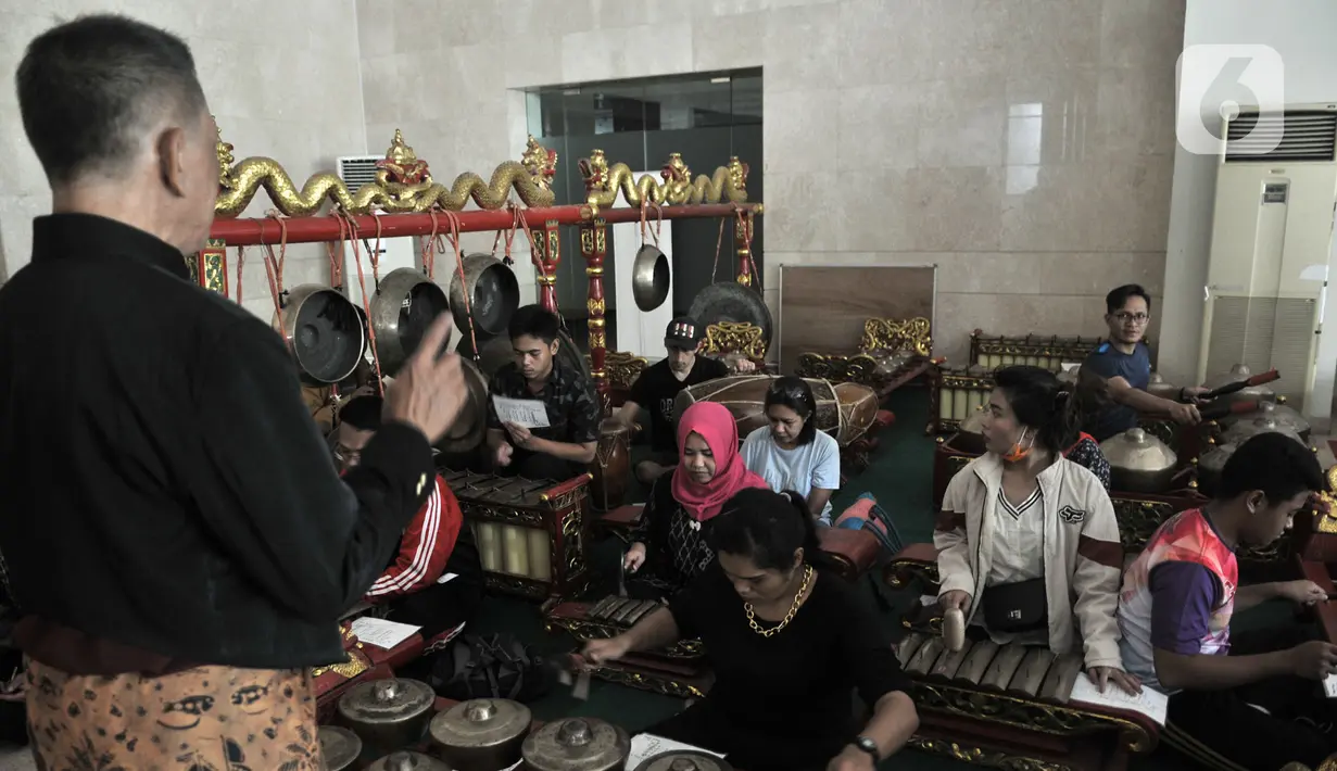 Pengunjung berlatih menjadi Nayaga atau penabuh gamelan saat lokakarya "Suara Dari Masa Lalu" di Museum Nasional, Jakarta, Minggu (22/12/2019). Lokakarya ini digelar dari 15 Desember 2019 hingga 5 Januari 2020. (merdeka.com/Iqbal S. Nugroho)