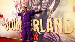 Aktor AS Jason Momoa berpose saat menghadiri pemutaran perdana film Netflix "Slumberland" di AMC Century City di Century City, California pada 9 November 2022. Momoa tampil mengenakan kemeja seperti piyama kancing ungu cerah. (AFP/Aude Guerrucci)