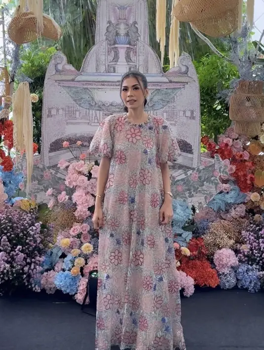 Ia pun tampil mengenakan dress panjang warna pastel dengan lengan balon memiliki detail bunga-bunga. Dipadukansilleto heels warna serasi. Rambutnya diikat ke belakang bergaya ponytail.[@putrihasibuan]