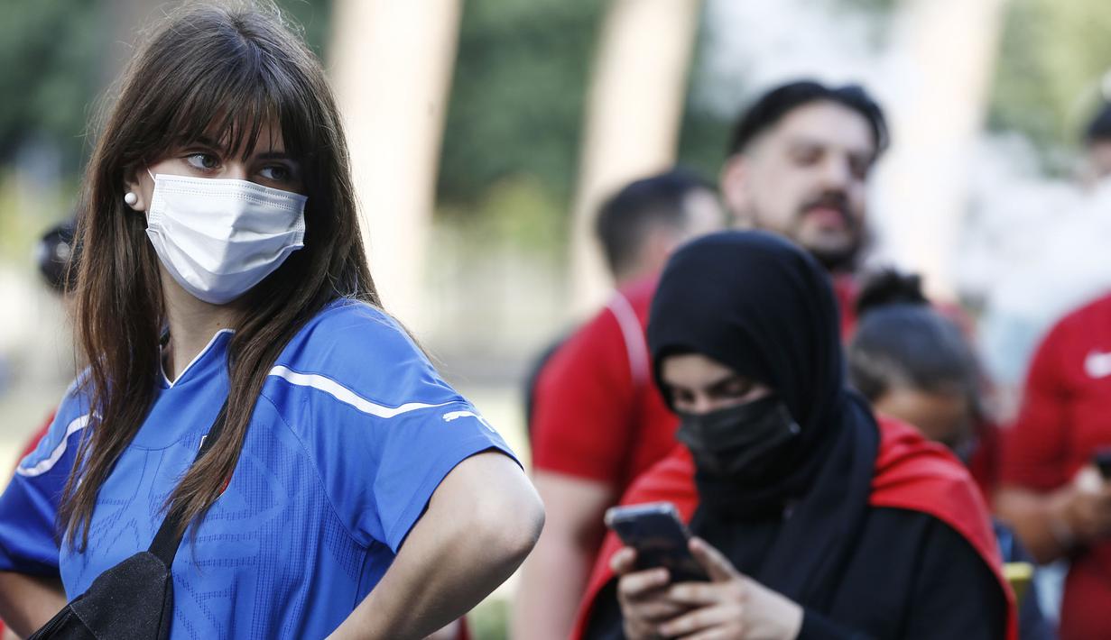 Walaupun harus menonton diluar stadion mereka pun tetap patuh pada protokol kesehatan salah satunya dengan memakai masker yang tak mengurangi kecantikan mereka. (Foto: AP/LaPresse/Cecilia Fabiano)