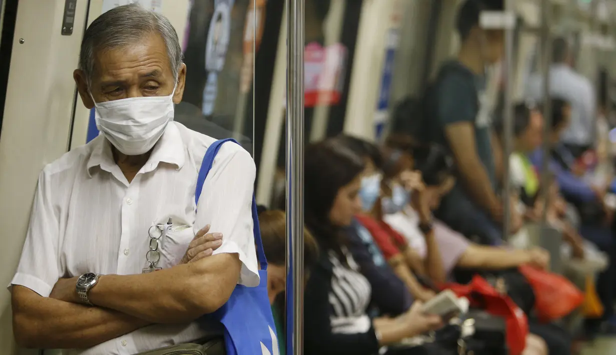 Warga memakai masker saat berada di dalam kereta api, Singapura (25/9/2015). Menurut Badan Lingkungan Nasional Singapura kabut Polutan Standar Indeks (PSI) mencapai tinggi 341 pada hari Jumat. (REUTERS/Edgar Su)
