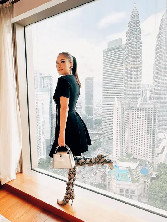 <p>Kali ini Bunga mengenakan black dress dan boots tinggi motif snakeskin. Dilengkapi dengan hand bag, penampilannya terlihat anggun dan asik. [Intagram/bclsinclair]</p>