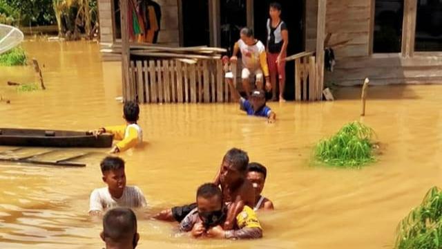 Personel Polres Indragiri Hulu bersama prajurit TNI mengevakuasi korban banjir.