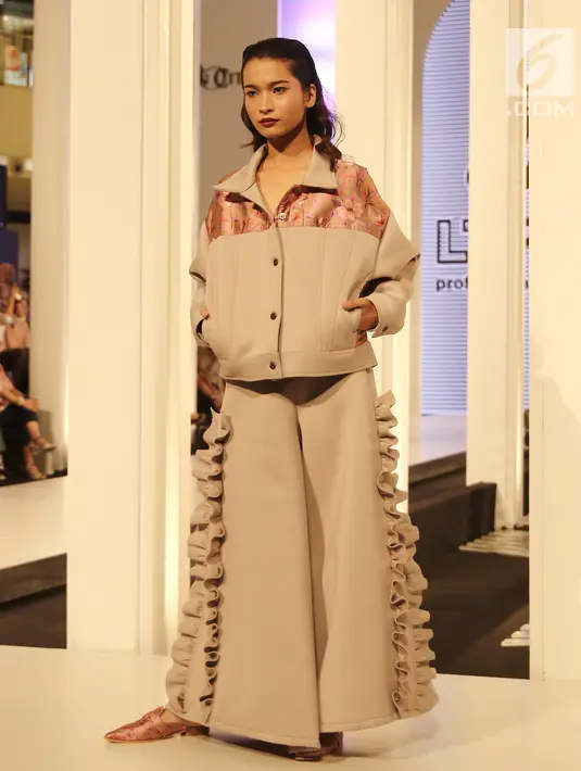 Gaya model saat mengenakan busana rancangan Tities Sapoetra dalam Fashion Nation 2018 di Senayan City, Jakarta, Rabu (18/4/). (Liputan6.com/Herman Zakharia)