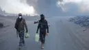 Petugas kepolisian berjalan di dekat kilang minyak yang dibakar oleh ISIS di Qayyara, selatan Mosul, Irak, (23/11). Sebelumnya, sekitar enam sumur minyak telah dibakar ISIS di kawasan tersebut. (REUTERS/Goran Tomasevic)