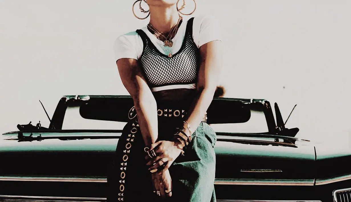 Agnezmo jadi salah satu artis yang kerap tampil dengan busana oversized. Dalam salah satu video klipnya, Agnezmo tampil kasual dengan kulot jeans dan t-shirt putih. Untuk tampilan yang lebih edgy, ia menggunakan bra net dan anting besar berwarna emas (instagram/agnezmo)