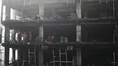 Anggota Pasukan Tanggap Bencana Nasional dan petugas pemadam kebakaran memeriksa sebuah gedung komersial sehari setelah kebakaran terjadi di New Delhi, India, Sabtu (14/5/2022). Kebakaran yang melanda gedung perkantoran empat lantai di Delhi, pada Jumat 13 Mei 2022, menewaskan sedikitnya 27 orang dan melukai sedikitnya 12 orang, kata layanan darurat. (Sajjad HUSSAIN / AFP)