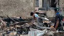 Seorang anak melihat telepon pintarnya di lokasi bekas kebakaran di permukiman padat penduduk di Jalan Kemayoran Gempol belakang Pasar Jiung, Kelurahan Kebon Kosong, Kecamatan Kemayoran, Jakarta Pusat, Selasa (2/6/2026). (Kapanlagi.com/Budy Santoso)