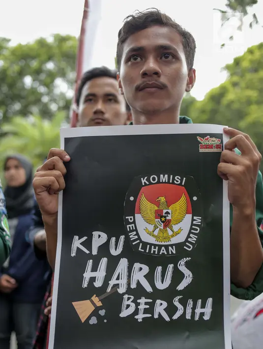 Seorang mahasiswa menunjukkan poster saat menggelar aksi di Gedung KPU, Jakarta, Selasa (23/4). Dalam Aksinya mereka mendesak KPU RI segera menyelesaikan permasalahan pemilu dan responsif dalam menindak  aduan masyarakat demi tercapai pemilu yang bersih dan adil. (Liputan6.com/Faizal Fanani)