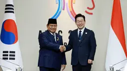 Presiden Indonesia Prabowo Subianto (kiri) berjabat tangan dengan Presiden Korea Selatan Lee Jae Myung menjelang pertemuan mereka di Pertemuan Pemimpin Ekonomi Kerja Sama Ekonomi Asia-Pasifik (APEC) di Gyeongju, Korea Selatan, Sabtu, 1 November 2025. Presiden Prabowo disambut secara langsung Presiden Korea Selatan, Lee Jae Myung dalam suasana penuh keakraban dan saling menghormati. Kedua pemimpin kemudian mengabadikan momen pertemuan tersebut dalam sebuah foto bersama sebagai simbol persahabatan dan kemitraan erat antara Indonesia dan Korea Selatan. (Yonhap via AP)