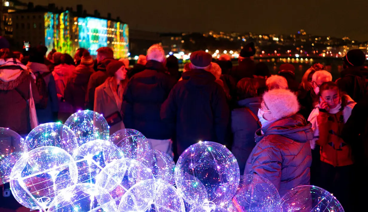 Orang-orang menghadiri pertunjukan cahaya malam di Lyon, Prancis, 8 Desember 2022. Jutaan orang diperkirakan akan menyaksikan acara Festival Cahaya selama empat hari di kota tersebut. (AP Photo/Laurent Cipriani)