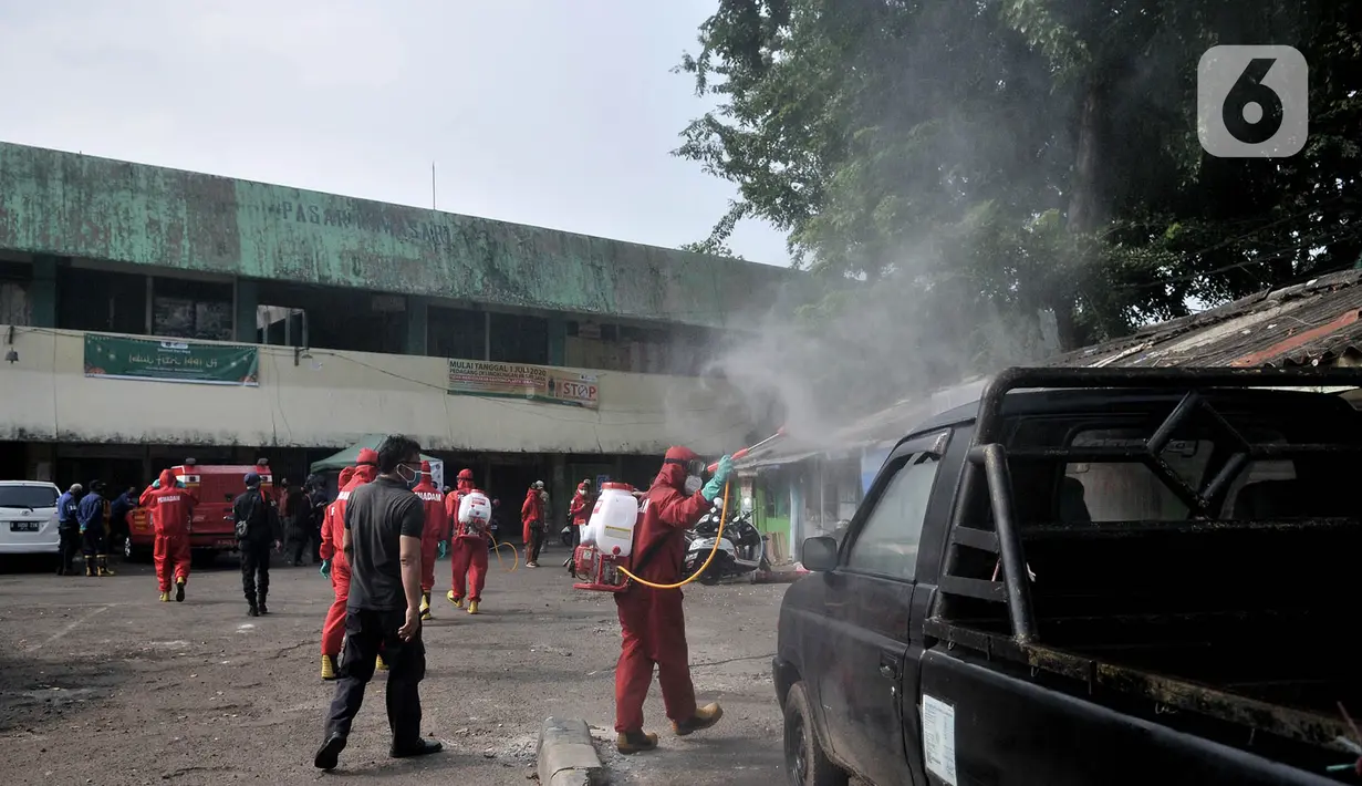 Pedagang menyaksikan petugas pemadam kebakaran Jakarta Pusat menyemprotkan disinfektan di Pasar Rawasari, Jakarta, Kamis (11/6/2020). Pihak pengelola menutup Pasar Rawasari selama tiga hari ke depan guna mensterilisasi serta memutus penyebaran Covid-19. (merdeka.com/Iqbal S. Nugroho)