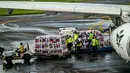 Para pekerja memuat barang bawaan jamaah haji Indonesia ke pesawat Saudia Airlines sebelum diberangkatkan di Bandara Internasional Juanda, Sidoarjo, Jawa Timur, Rabu 22 April 2026. (JUNI KRISWANTO/AFP)