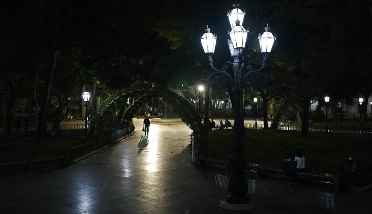 Seseorang berjalan melalui Bolivar Square di pusat Kota Caracas, Venezuela, 5 Februari 2022. (AP Photo/Ariana Cubillos)