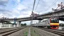 Kereta Commuter Line melintas di bawah proyek pembangunan jalur lintas atas (flyover) Cakung, Jakarta, Kamis (17/12/2020). Proyek Flyover Cakung saat ini telah mencapai 94 persen dan sedang menyelesaikan pemasangan balok girder pada bentang yang melintasi rel kereta api. (merdeka.com/Iqbal Nugroho)