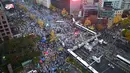 Serikat buruh dan organisasi massa mengadakan aksi besar-besaran di Seoul, Sabtu (14/11/2015). Mereka memprotes rencana pemerintah untuk mengadopsi buku pelajaran sejarah untuk siswa dan langkah-langkah mereformasi tenaga kerja. (AFP Photo/Jung Yeon)