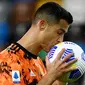 Striker Juventus, Cristiano Ronaldo, mencium bola saat melawan Udinese pada laga Liga Italia di Dacia Arena, Minggu (2/5/2021). Juventus menang dengan skor 1-2. (AFP/Marco Bertorello)