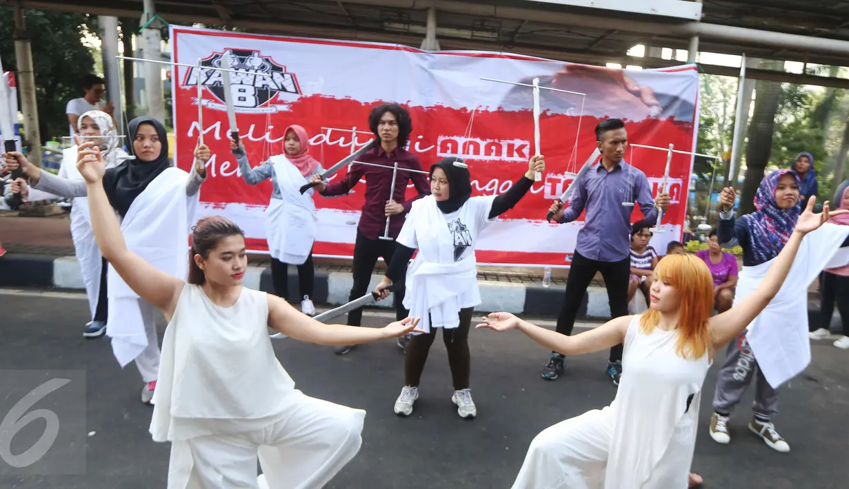 Sejumlah orang yang tergabung dalam relawan Kawan8 dan Mahasiswa IKJ yang menggelar flashmob di Jalan Jenderal Sudirman, Jakarta, Minggu (5/3). Acara tersebut diwarnai aksi teatrikal. (Liputan6.com/Helmi Afandi)