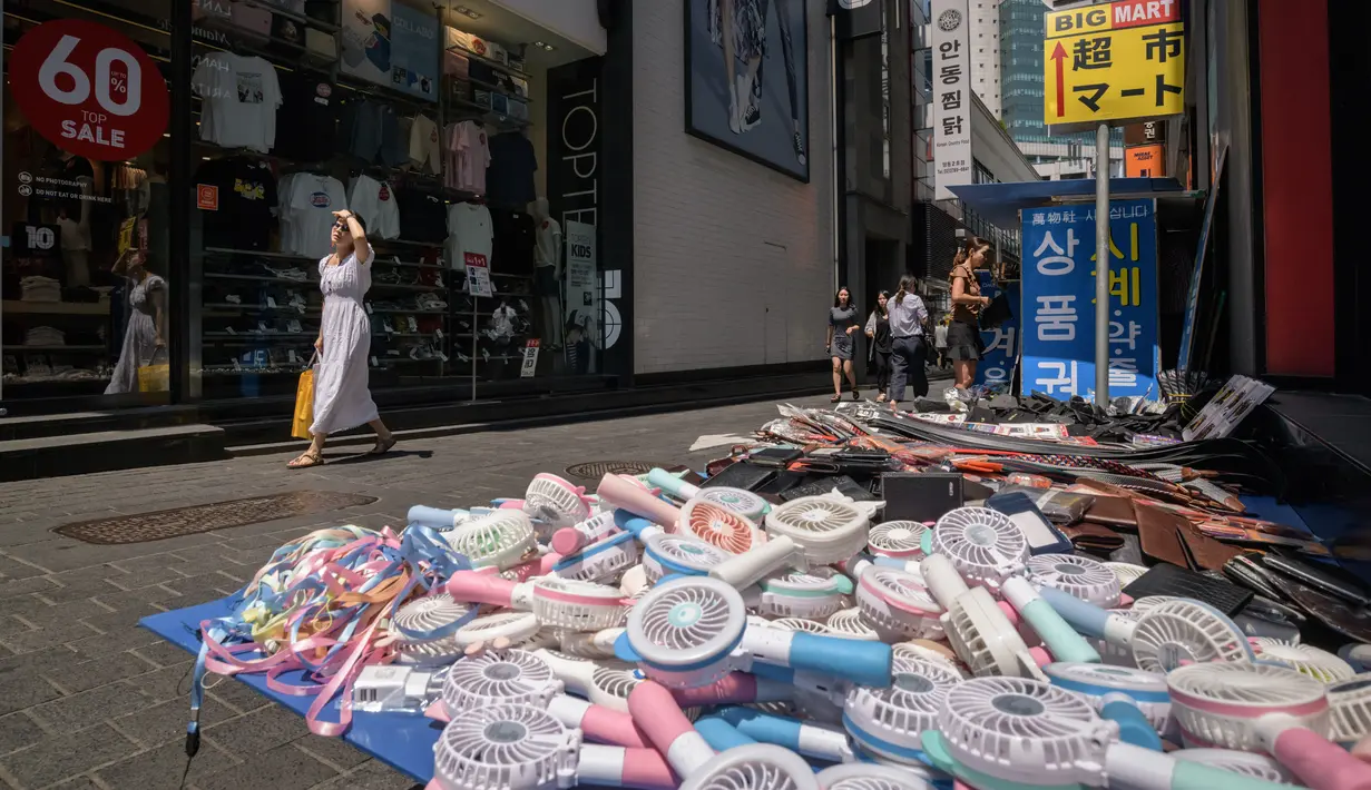 Kipas listrik dijual di distrik perbelanjaan Myeongdong, Seoul, Korea Selatan, Rabu (1/8). Korea Selatan mengalami gelombang panas panjang setelah musim hujan dengan curah rendah dan tekanan atmosfer dari Tibet yang tinggi. (Ed JONES/AFP)