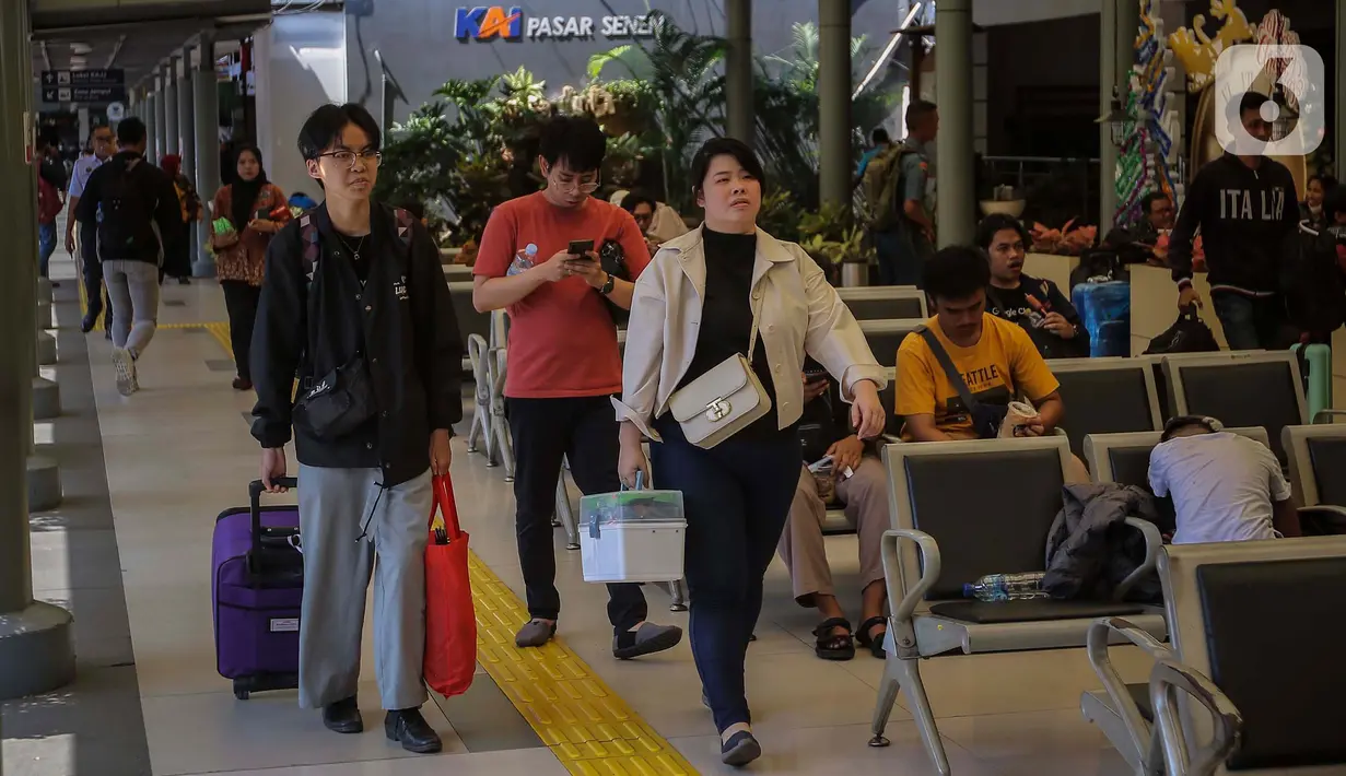 Penumpang berjalan dengan membawa barang bawaannya di Stasiun Senen, Jakarta, Kamis (21/12/2023). (Liputan6.com/Angga Yuniar)