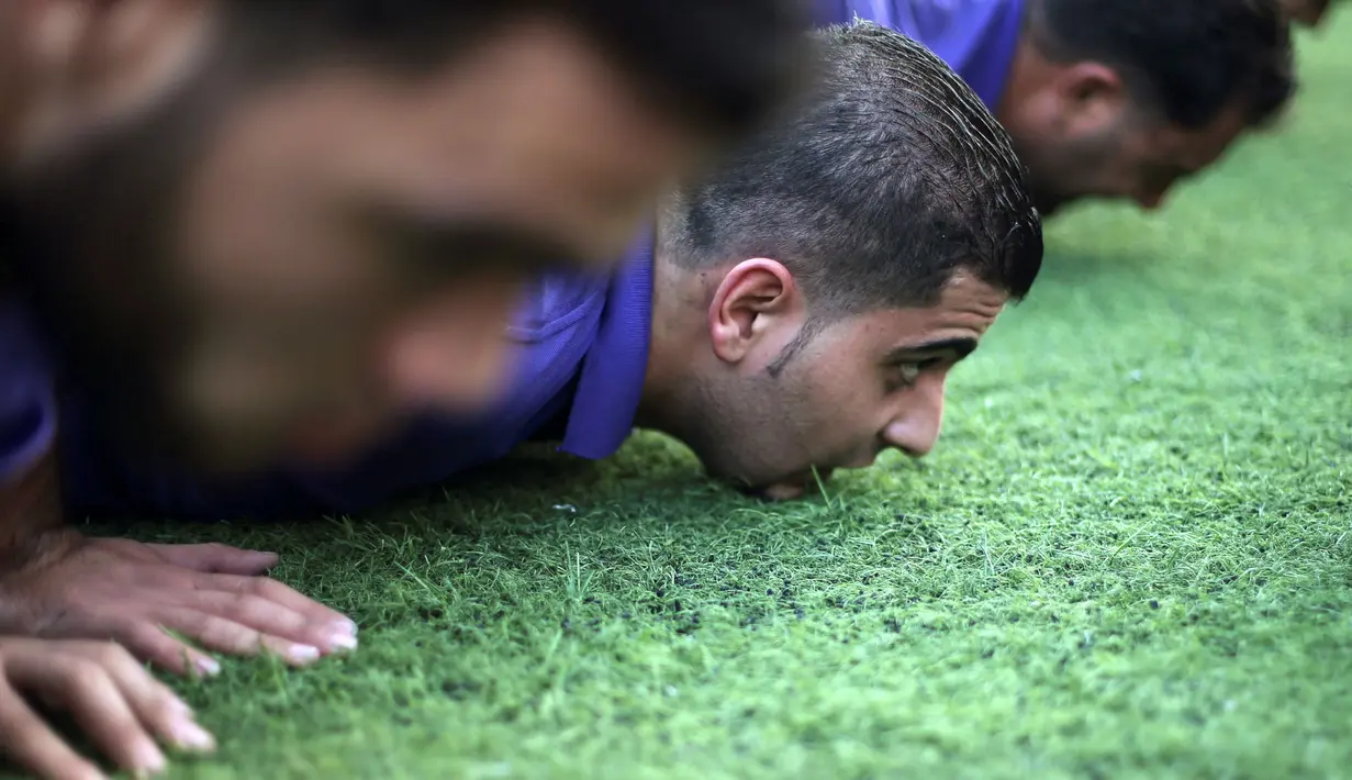 Para calon anggota penjaga keamanan pribadi melakukan push-up saat menjalani pelatihan di taman bermain terbuka di Kota Gaza (21/11). (REUTERS/Ibraheem Abu Mustafa)