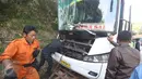 Petugas saat akan mengevakuasi bus PO Merdeka yang menabrak pohon di jalur Lingkar, Jawa Barat, Sabtu (2/7). Tidak ada korban jiwa akibat kecelakaan bus yang disebabkan rem blong tersebut. (Liputan6.com/Immanuel Antonius)