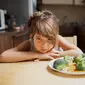 Seorang Anak Perempuan Terlihat Enggan Memakan Sayur (freepik)