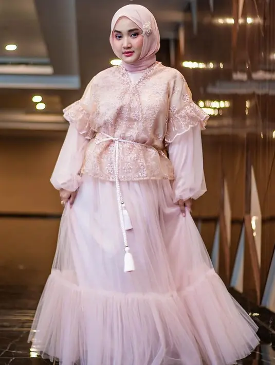Fatin juga hadir dengan tampilan serba pink, ia mengenakan atasan lace dipadukan inner dress tulle dari Pixietale ditambah belt tali putih. Dengan kerudung pink yang dihiasi hair clip bunga. [@fatin30)]