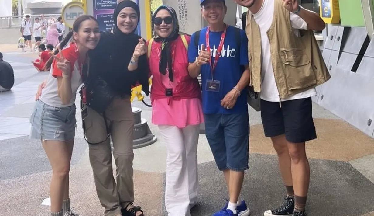 Omesh dan Dian Ayu Lestari juga berlibur ke Singapura, namun tidak bersama anak-anaknya. Nampak Dian pun mengenakan atasan hitam yang serasi dengan kerudungnya dipadukan celana cargo coklat.  @ayutingting92