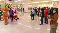Petugas yang mengenakan kostum Sinterklas melayani foto bersama pengunjung di Senayan City Mall, Jakarta, Jumat (25/12/2020). Pengunjung bisa berswafoto dan menikmati momen Natal bersama keluarga dan orang terkasih dengan "Santa and Friend". (Liputan6.com/Herman Zakharia)