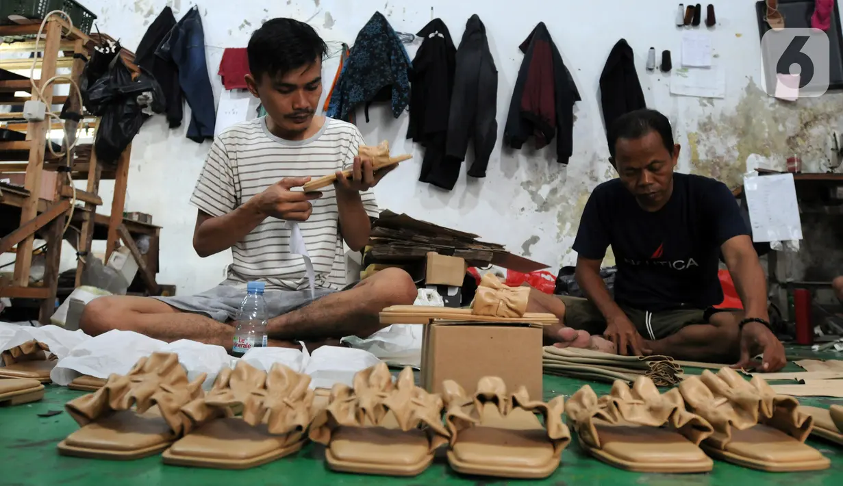 Perajin alas kaki menyelesaikan pembuatan sandal di kawasan Bojongsari, Depok, Jawa Barat, Selasa (22/2/2022). UMKM alas kaki kembali tumbuh menggeliat setelah sempat goyang pada awal masa pandemi yang menyebabkan sejumlah UMKM tutup tidak beroperasi. (merdeka.com/Arie Basuki)