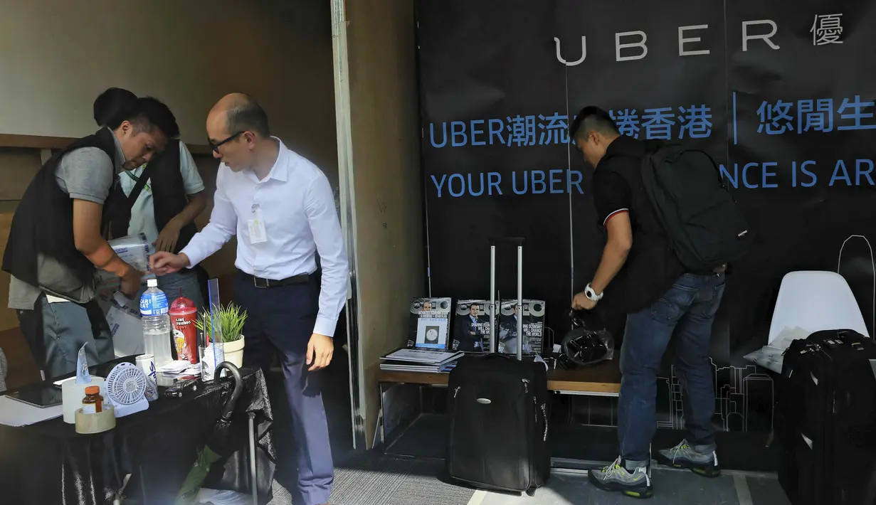 Polisi Hong Kong melakukan razia di kantor jasa pelayanan taxi Uber Inc, Selasa (11/8/2015). Polisi berhasil mengamankan 5 orang yang tertangkap basah memberikan jasa pelayanan sebagai sopir taxi dengan kendaraan ilegal. (REUTERS/Apple Daily)
