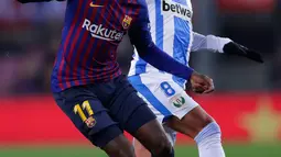 Pemain Barcelona, Dembele berebut bola dengan pemain Leaganes, Jose Luis Garcia pada pertandingan pekan ke-20 La Liga Spanyol, di Camp Nou, Senin (21/1). Barcelona kian kokoh di puncak klasemen usai menang 3-1 atas Leganes. (AP/Manu Fernandez)